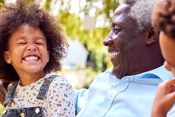 Happy smiling senior randparents playing with their granddaughter