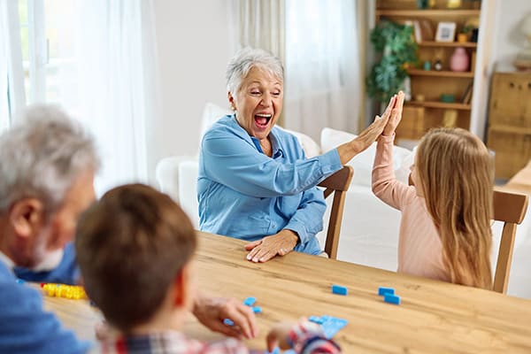 Happy smiling senior randparents playing with their granddaughter